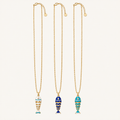 Three gold chain necklaces with fish-shaped pendants, displayed vertically on a light cream background. The left and right necklaces feature light blue and white patterned fish, while the center necklace features a dark blue and yellow striped fish.