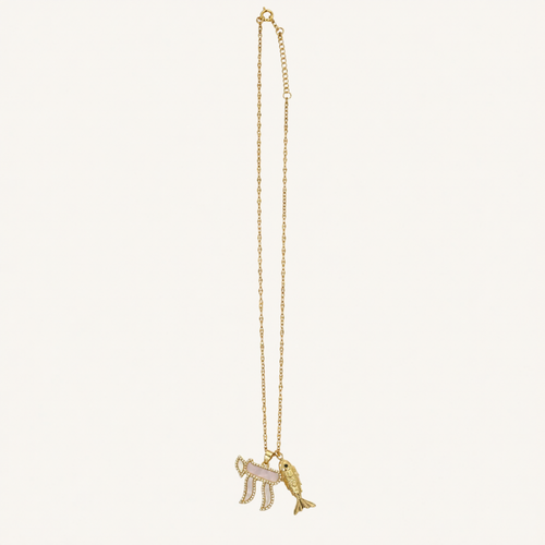 A gold chain necklace featuring a pendant with a pink and white striped flag and a gold fish, displayed against a solid off-white background.
