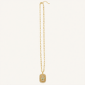 A gold chain necklace featuring a rectangular pendant encrusted with small clear stones and a central white stone, displayed against a solid off-white background.