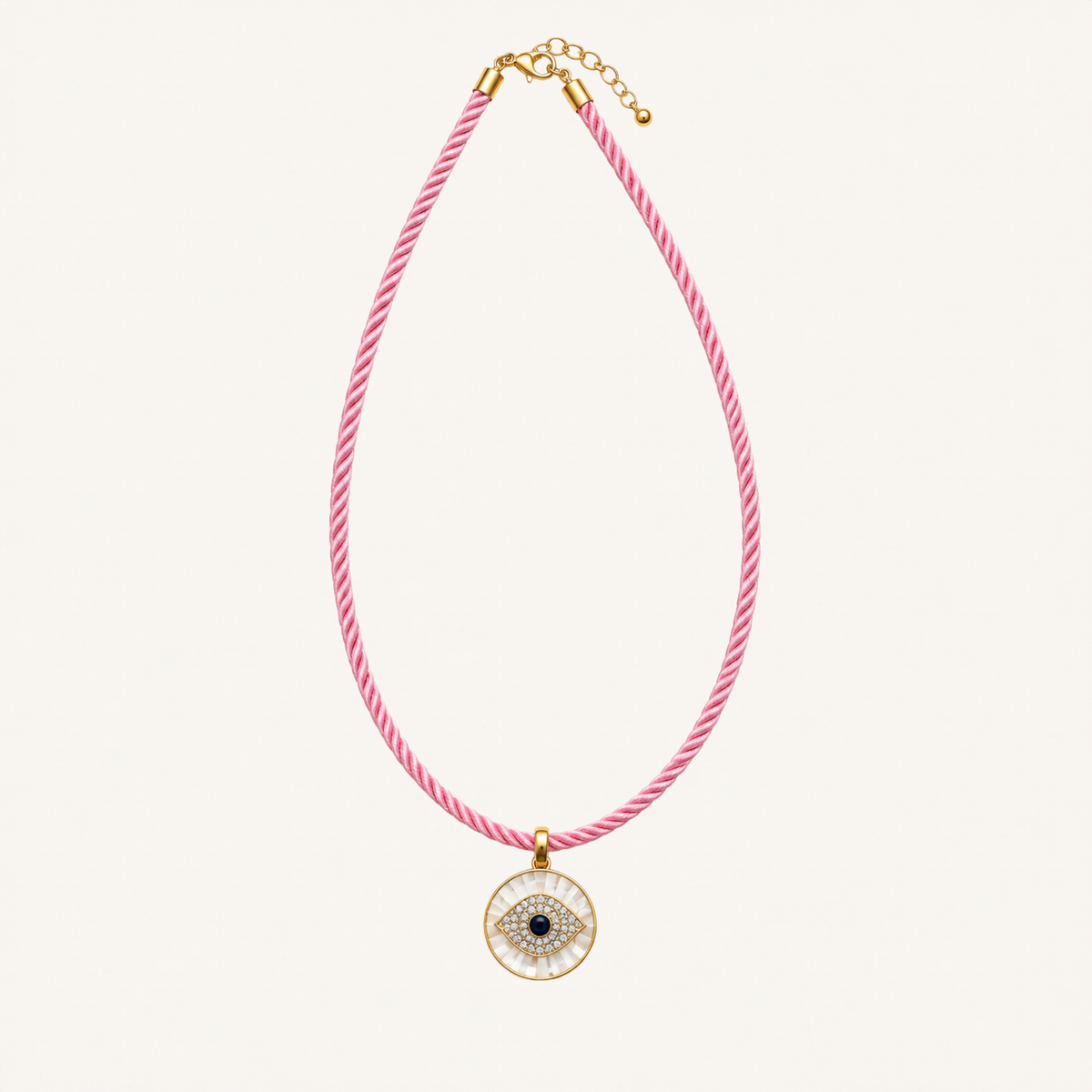 A pink and white twisted rope necklace with a gold-tone evil eye pendant, displayed on a clean off-white background.