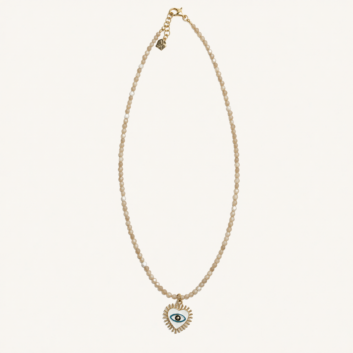White beaded necklace with a heart-shaped evil eye pendant.