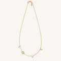 A delicate gold chain necklace featuring Hebrew letters and a Star of David charm, displayed against a solid off-white background.
