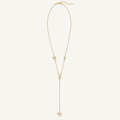 A delicate gold Y-necklace featuring a main chain with a small star, an eye-shaped charm, a central floral cluster, and a long drop chain ending in a butterfly pendant, displayed on a clean off-white background.