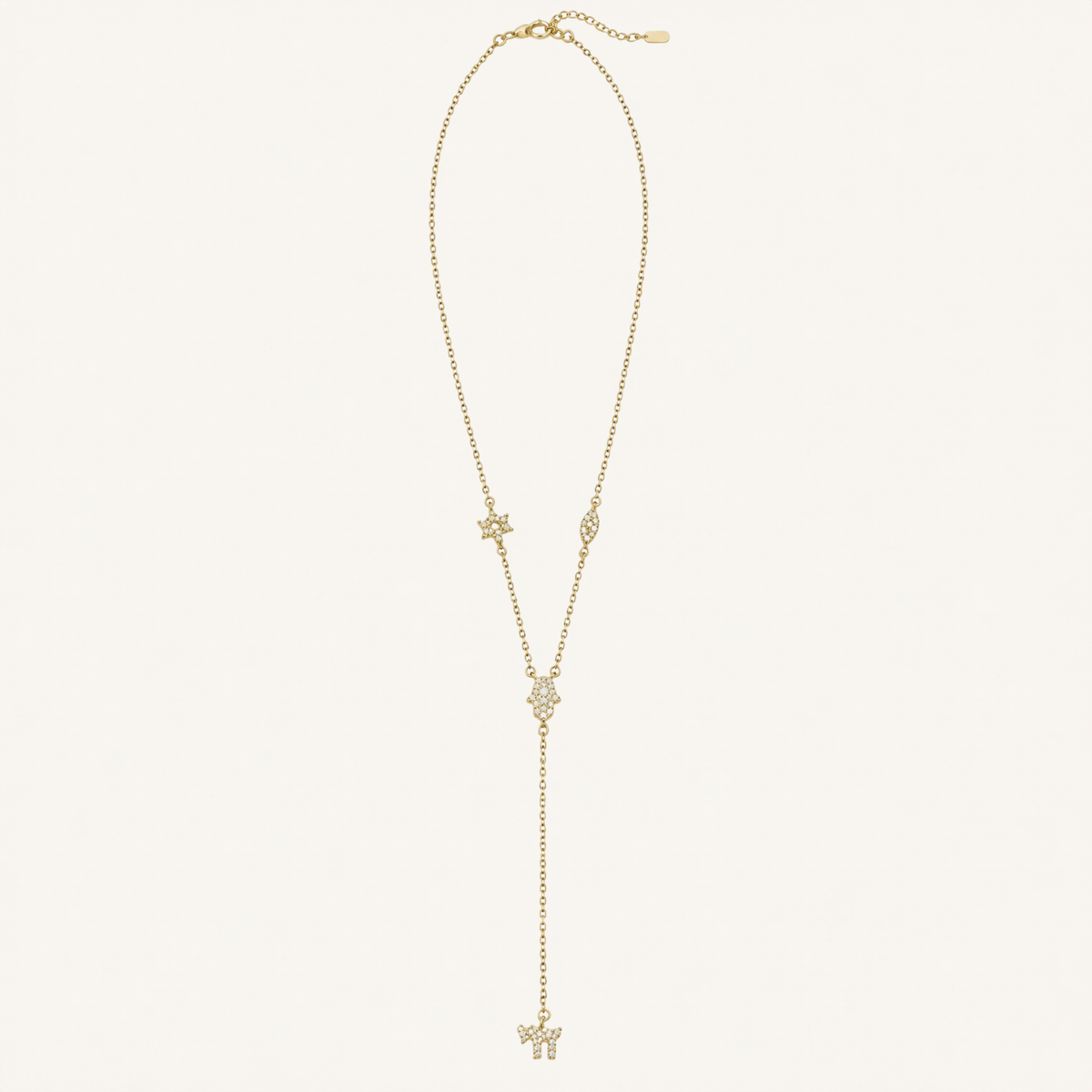 A delicate gold Y-necklace featuring a main chain with a small star, an eye-shaped charm, a central floral cluster, and a long drop chain ending in a butterfly pendant, displayed on a clean off-white background.